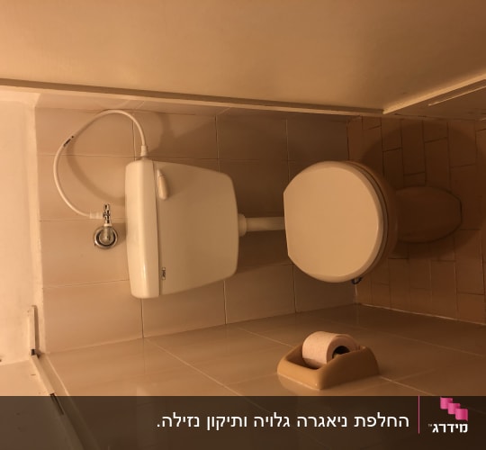 אסלה עם מיכל הדחה וצינור מים